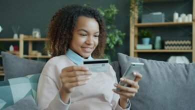 Person using a smartphone and payment card at home; illustrative image for an online banking guide, not a St.George Bank app screenshot