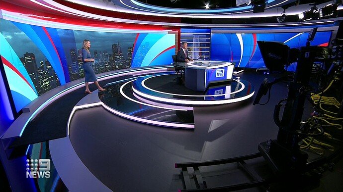Nine News studio with the 9NEWS logo on screen