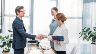 Job applicant shaking hands with an employer during a job interview in a modern office