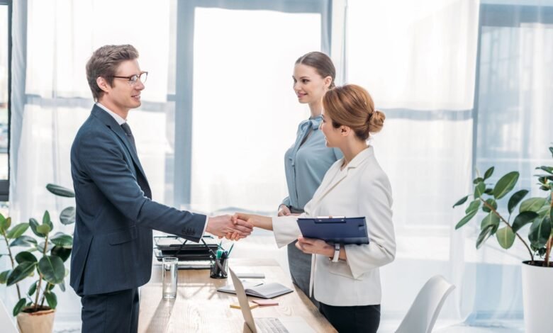 Job applicant shaking hands with an employer during a job interview in a modern office