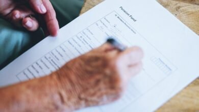 Hands filling out a pension fund form on paper