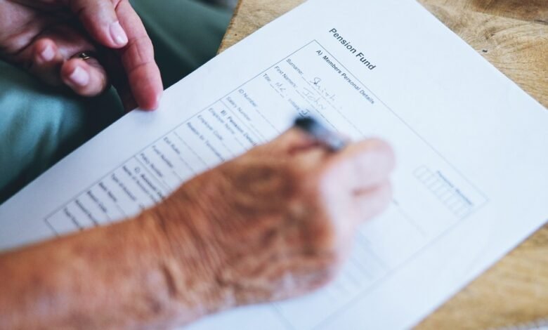 Hands filling out a pension fund form on paper
