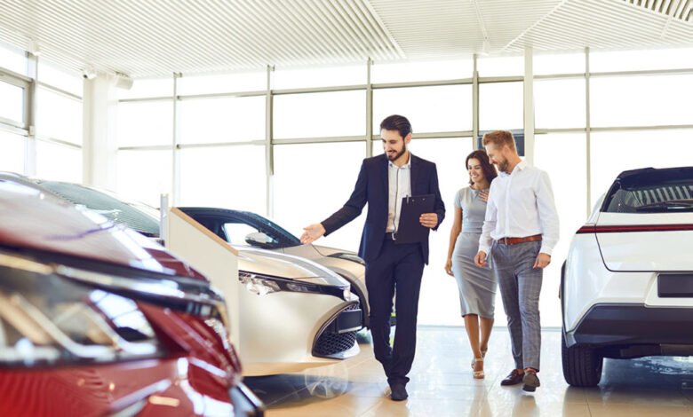 Couple looking at new cars in a dealership showroom